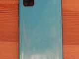 a close up of the back of a blue phone on a wooden table