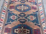 a close up of a blue and red rug on a floor