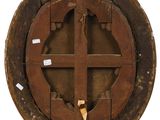 an old wooden circular window with a cross on it