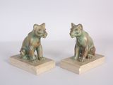 paire de figurines en bronze représentant un chat et un chien, posées sur des socles en bois
