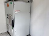 a small refrigerator in the corner of a room next to a wall