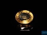 a close up of a yellow diamond on a black surface