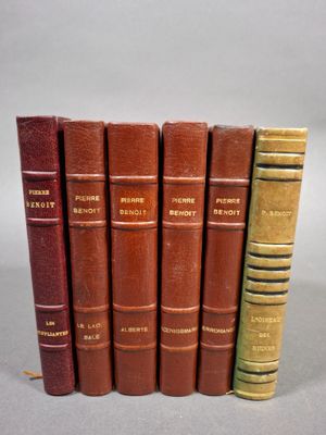 six vieux livres sont alignés sur une table