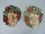 deux figurines en céramique représentant un homme et une femme avec des grappes de raisin sur la tête