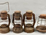 Quatre lampes à huile à l'ancienne sont alignées sur une surface blanche
