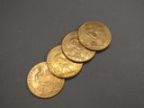 five gold coins sitting on top of each other on a table