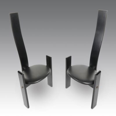 une paire de fauteuils en cuir noir à dossier incurvé