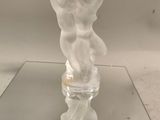 une figurine en verre posée sur une table en verre
