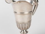 an antique silver cup with a spoon and spoon in it