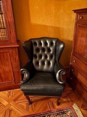 un fauteuil en cuir noir placé dans un coin d'une pièce