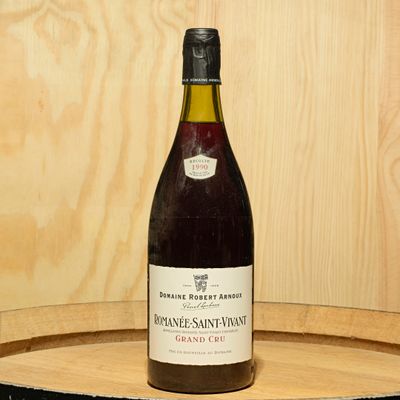 a bottle of wine sitting on top of a wooden barrel