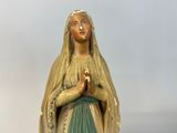 a statue of a woman with a rosary in her hands