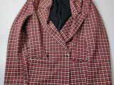 red and white checkered blazer with black tie on a hanger