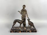 statue en bronze représentant une femme et deux chiens, posée sur un socle en marbre