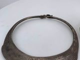 two pieces of silver jewelry on a white table