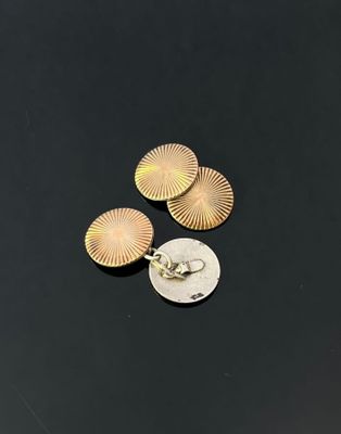 a close up of three gold earrings on top of a coin