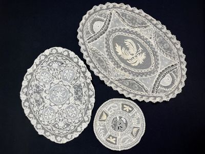 three pieces of lace on a black table cloth