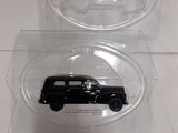 two clear plastic boxes with a black car in them