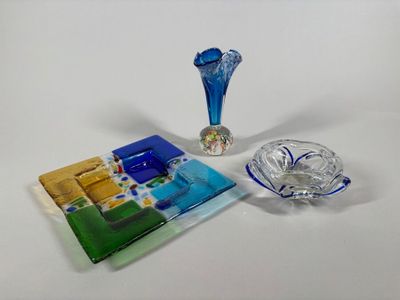 a blue glass vase and a blue plate on a white table
