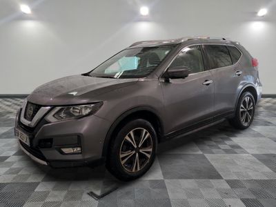 un SUV Nissan gris garé dans un garage au sol carrelé