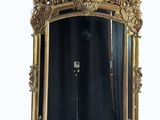 a mirror with a gold frame on a white wall