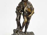 une vieille statue en bronze représentant un homme tenant un chien