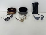 three pairs of sunglasses and a case on a white surface