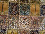 de nombreux tapis de différentes couleurs exposés dans une pièce