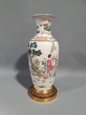 un vase blanc avec un socle doré et une peinture dessus