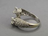 an image of a silver ring with a diamond and a white stone