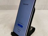 a close up of a cell phone on a stand on a bed