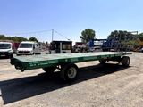 a green flatbed trailer parked in a parking lot