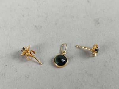 a pair of gold earrings with a black stone