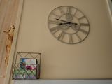 a clock that is on the wall above a shelf