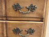 an image of a wooden dresser with brass handles