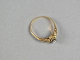 a close up of a gold ring with a diamond on it
