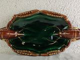 a green and gold plate with two bees on it