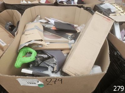 une boîte en carton remplie d'objets divers et une paire de ciseaux verts
