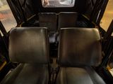 two black seats in the back of a bus