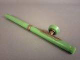 a green pen sitting on top of a white table