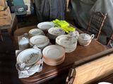 many plates and cups sitting on a table in a room