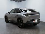 the rear end of a silver car in a white room