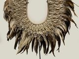 an image of a necklace made of feathers on a black stand