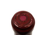 a close up of a bottle of wine on a white surface