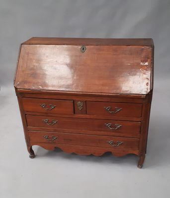 un vieux bureau en bois avec des tiroirs, surmonté d'autres tiroirs