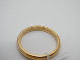 gros plan d'une bague en or sur une surface blanche
