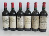 six bottles of wine are lined up in a row on a table