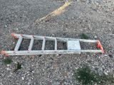 a ladder laying on the ground in a parking lot