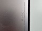the back of a silver laptop computer sitting on top of a white table