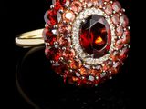 une image représentant une bague en diamant rouge et blanche posée sur une surface noire